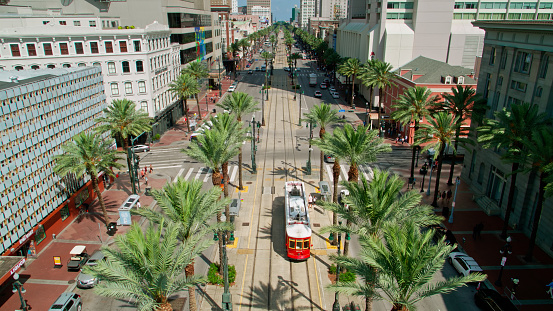 Aerial shot of New Orleans, Louisiana on a sunny summer morning, looking along Canal Street and a red streetcar, towards the central business district.