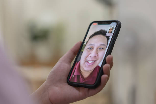 istock Focusing at hand with phone while a woman using video calling with husband 1341972515
