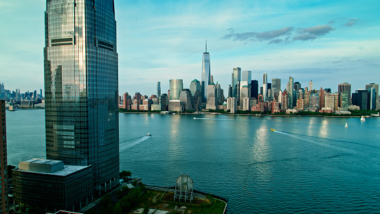 Drone shot of the waterfront of Jersey City with the skyline of Lower Manhattan visible across the Hudson River.