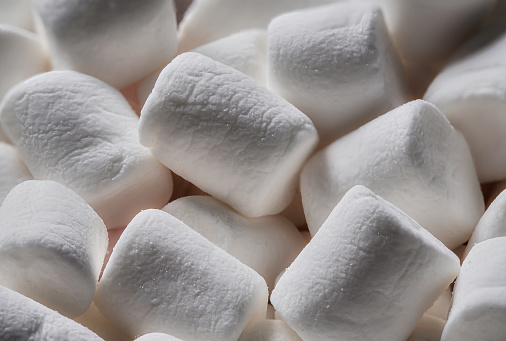 High angle extreme close-up background of an assortment of  white colorful marshmallows
