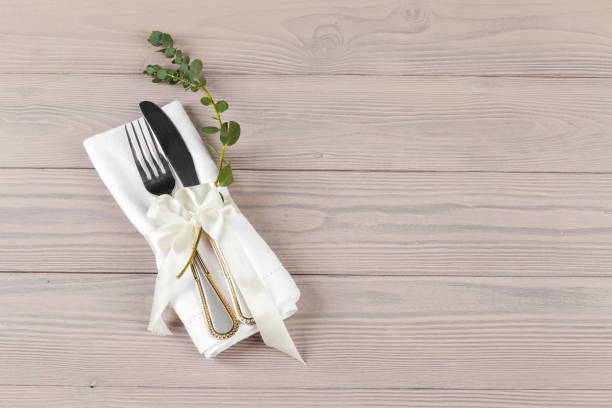 istock Cutlery wrapped in a napkin on a wooden table 1341977206