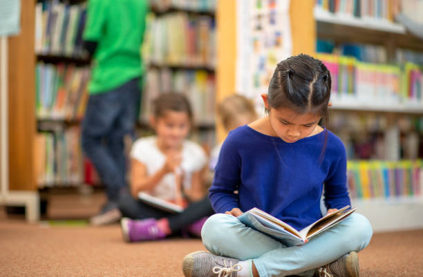 istock Little Girl Reading alone in the Library 1341978020