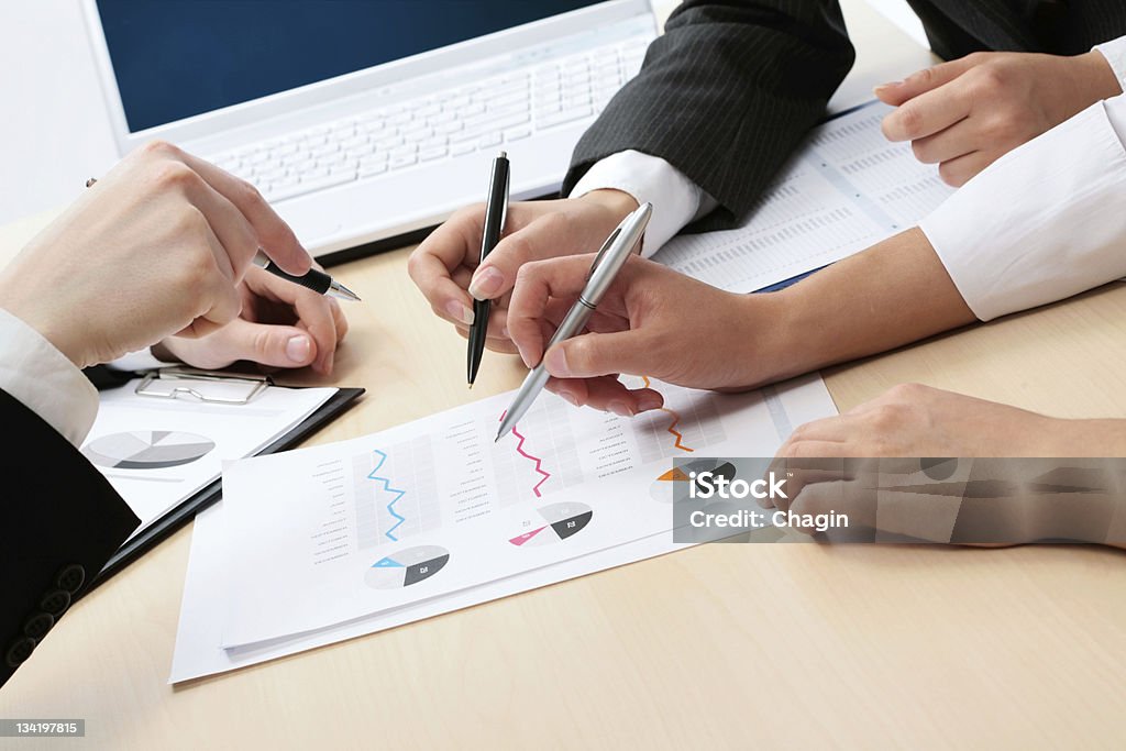 Business people hands Close-up of businessman hand with pen explaining a financial plan to colleagues at meeting Analyzing Stock Photo