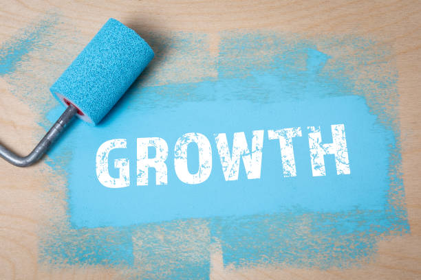 istock GROWTH. Blue color and paint roller on a wooden background 1341983551