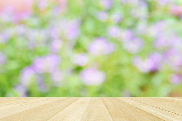 istock Empty top wooden table on soft focus blurred flowers field for background 1341984493