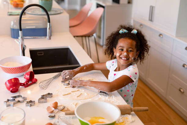 istock Happy african american messy girl baking in kitchen 1341991543