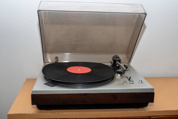 istock Analog retro vintage stereo turntable on a wooden table. An old-fashioned plastic turntable playing a music track 1341992400