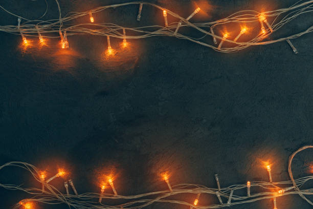 istock Warm light illuminated garland close up on dark background 1341992479