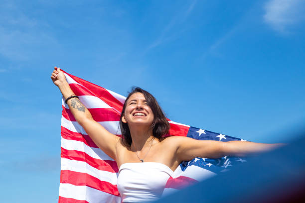 istock young beautiful woman holding USA flag 1341992649