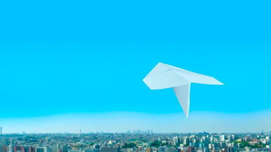 Paper airplanes flying over city buildings
