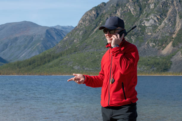 mężczyzna rozmawiający przez telefon satelitarny w górach - high peaks audio zdjęcia i obrazy z banku zdjęć