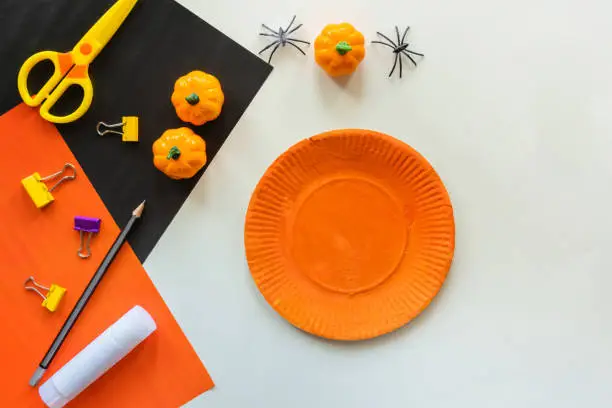 Cuts of paper for Halloween. Hand cut paper. Pumpkins. Scissors and glue. On a light background. Top view. Flat lay.