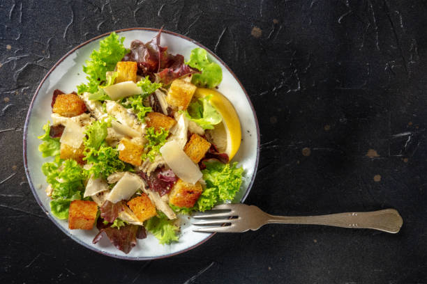 istock Chicken Caesar salad, shot from above on a black background 1341995856
