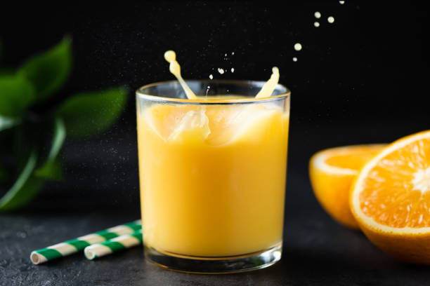 istock Orange juice with splash in a glass 1341997952
