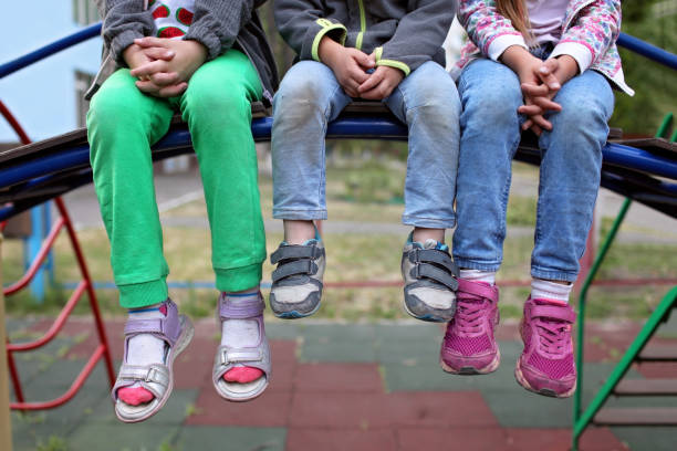 istock Three diverse kids sitting together on the bench 1342001646