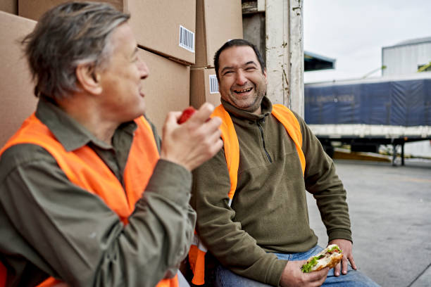 camionisti maschi che si godono la pausa pranzo all'aperto - truck driver multi ethnic group industry working class foto e immagini stock