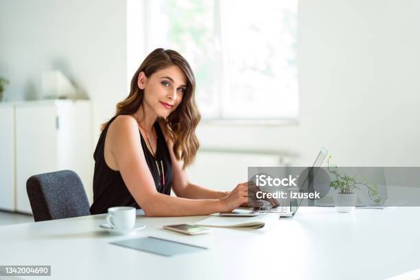 Young Woman Working On Laptop In The Office Stock Photo - Download Image Now - Copywriter, Freelance Work, Business