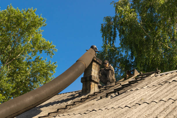 spazzacamino che pulisce il camino in mattoni sul tetto del vecchio edificio - chimney sweeping foto e immagini stock