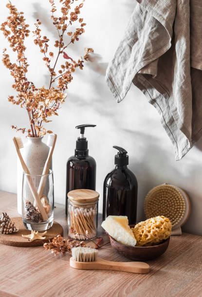istock Bathroom interior. Still life with decorative flowers, shampoo bottles, cotton buds, brushes, soap, towels on a wooden background. Minimalism scandinavian interior 1342011561