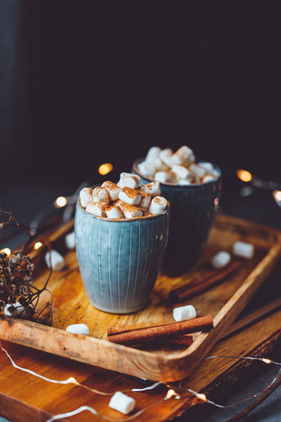 istock Hot chocolate with marshmallow and cinnamon in blue ceramic cups on a table. The concept of cosy holidays and New Year. 1342011996
