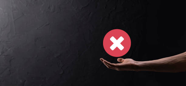 istock Hand holds icon,cancellation symbol,cancel icon.Cross mark flat red icon.round X mark.cancel button.Wrong.cross mark rejection.Declined.On dark background.Banner.Copy space.Place for text. 1342012000