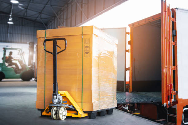 Cargo Box with Hand Pallet Truck  is Loading into a Container. Shipment Delivery. Warehouse Logistics. Cargo Freight Truck Transportation. Cargo Box with Hand Pallet Truck  is Loading into a Container. Shipment Delivery. Warehouse Logistics. Cargo Freight Truck Transportation. pallet industrial equipment stock pictures, royalty-free photos & images