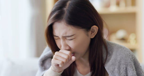 mujer asiática tos en casa - cough remedy fotografías e imágenes de stock