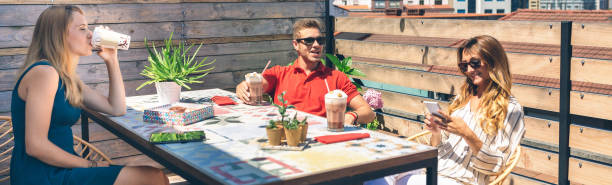 Group of happy friends having a drink on a terrace