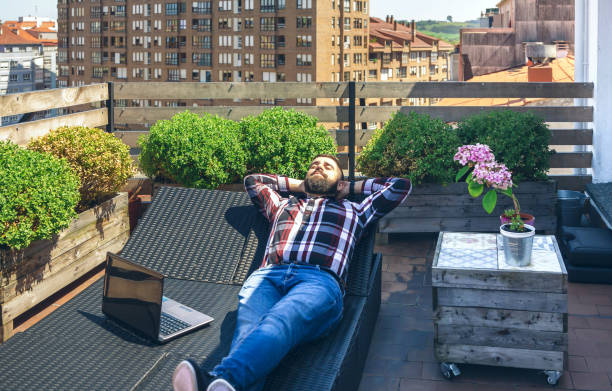istock Businessman resting on lounger on terrace 1342014828