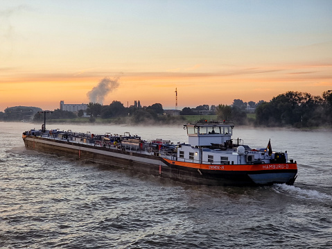 Binnenvaart, Translation Inlandshipping on the river Rhein Lobith Netherlands September 2021, during sunset hours, vessel transport Germany to Netherlands Inland Shipping