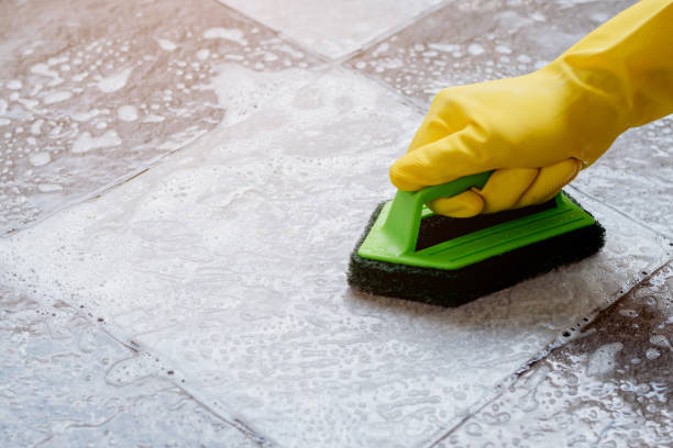 istock Cleaning the tiled floor with a green color plastic floor scrubber. 1342018397