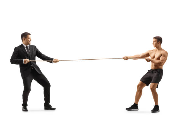 istock Full length profile shot of a businessman and a bodybuilder pulling rope from opposite sides 1342018521