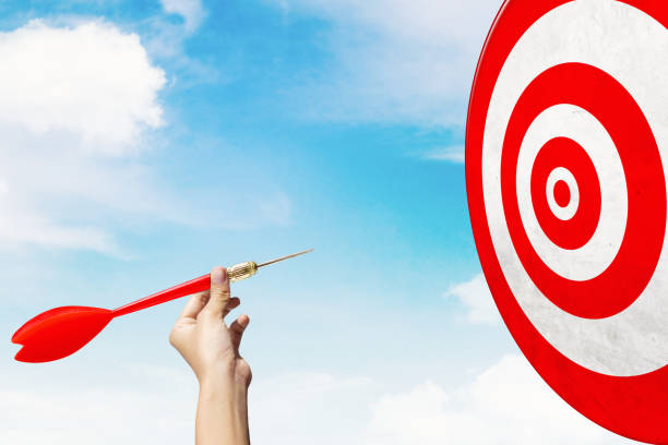 istock Businessman hand throwing a red dart to the target 1342021019