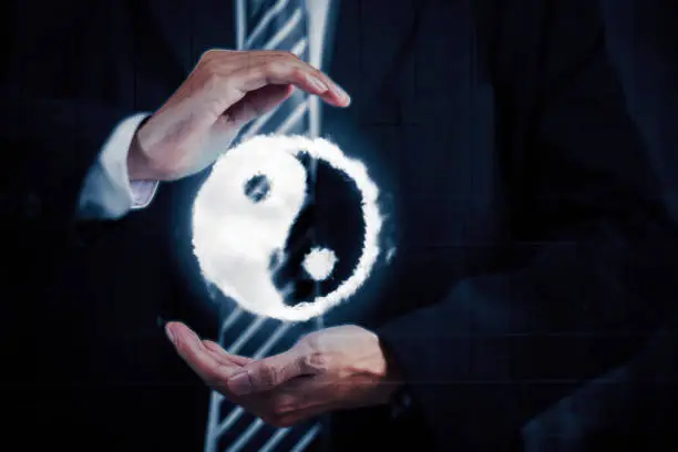 Close up of male manager holding yin yang symbol on his hands