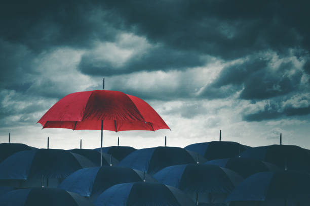 istock Red umbrella stand out from crowded black umbrellas 1342021075