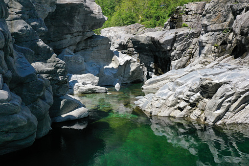 The Maggia (river) in the Swiss canton of Ticino. The river flows through the Valle Maggia, and enters Lago Maggiore between Ascona and Locarno.  The image shows the river between some beautiful rock formations in springtime.