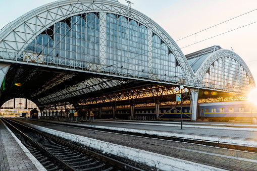 railway station in Lviv, Ukraine, illuminated by the evening autumn sun. Steel rails and glass roof on the apron. Tourism, public transport and travel in Europe