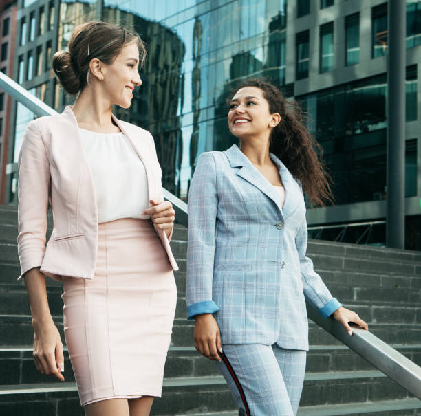 istock two office workers together on stairs near modern business building 1342023949