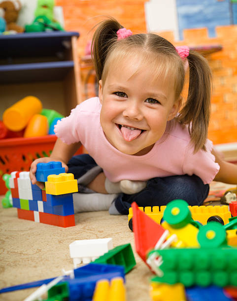 Little girl is playing with toys in preschool stock photo