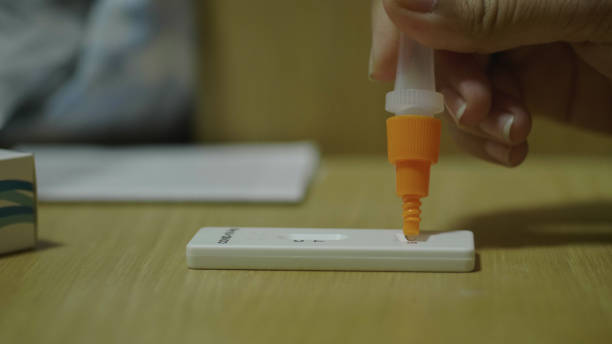 istock young asian woman using a home COVID test kit. 1342025660