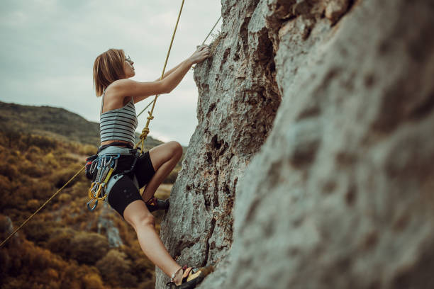 istock Young woman rock climbing on the cliff 1342027103