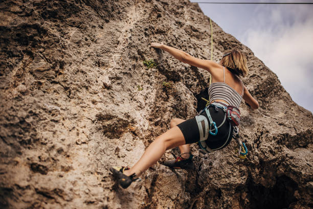 istock Determined young woman rock climbing on the cliff 1342027341