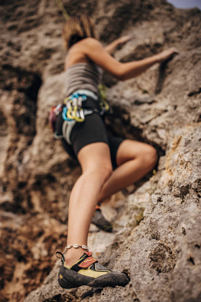 istock Young female rock climbing on the cliff 1342027416