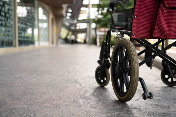 sedia a rotelle vuota nel corridoio in ospedale. attrezzature mediche in ospedale per l'assistenza ai portatori di handicap. - disablement foto e immagini stock