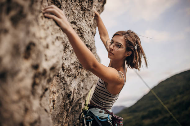 istock Determined young woman rock climbing on the cliff 1342027478