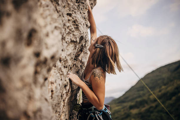istock Determined young woman rock climbing on the cliff 1342027543