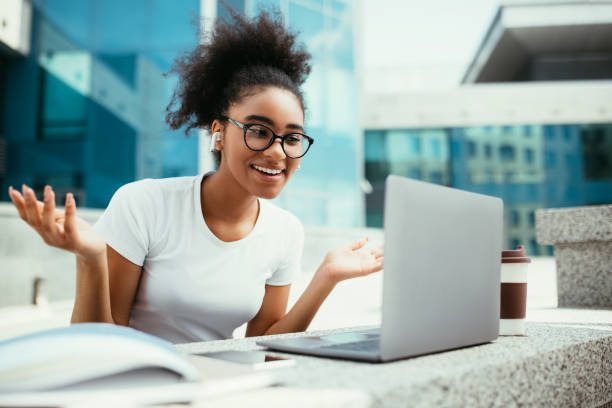 istock Black Student Video Calling Via Laptop Having Online Lecture Outdoors 1342027616