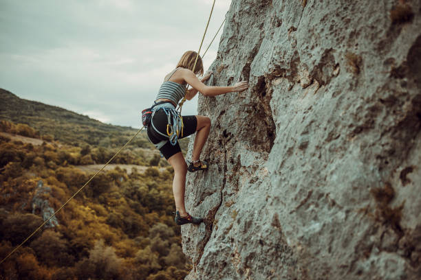 istock Young female rock climbing on the cliff 1342027863