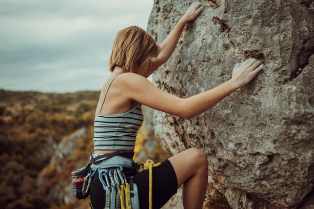 istock Young female rock climbing on the cliff 1342028423