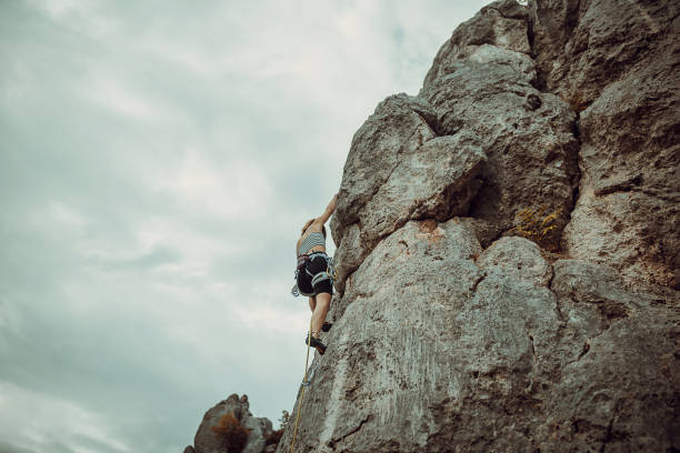 istock Young woman rock climbing on the cliff 1342028436